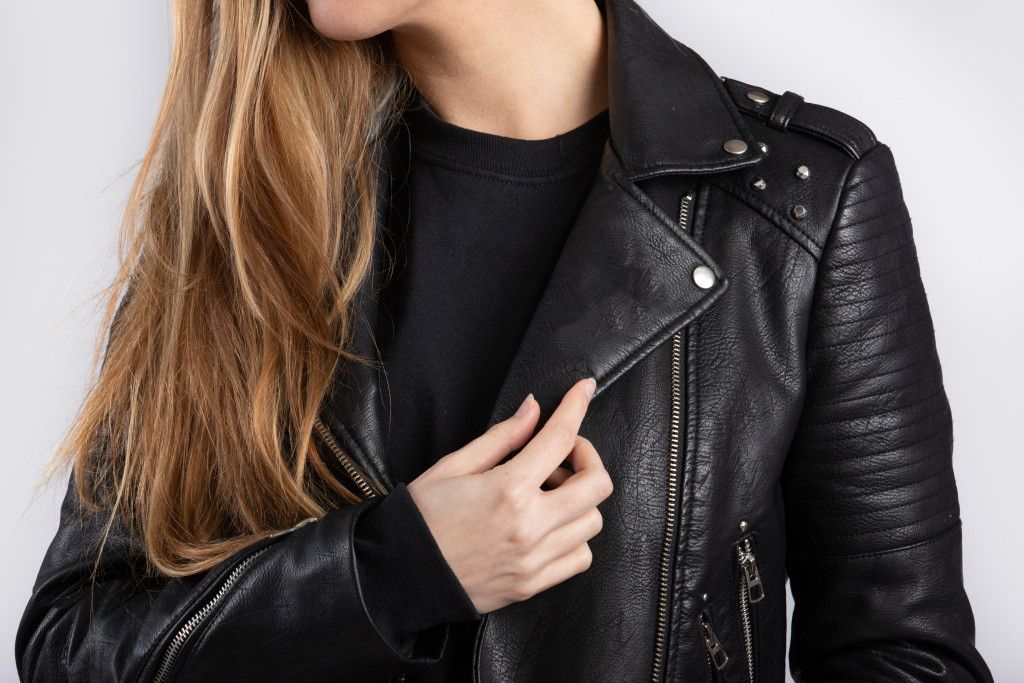 young-female-wearing-jacket-standing-against-white-wall.jpg